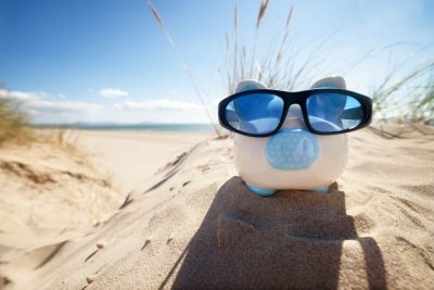 Piggy bank on the beach, taking a holiday from pension contributions